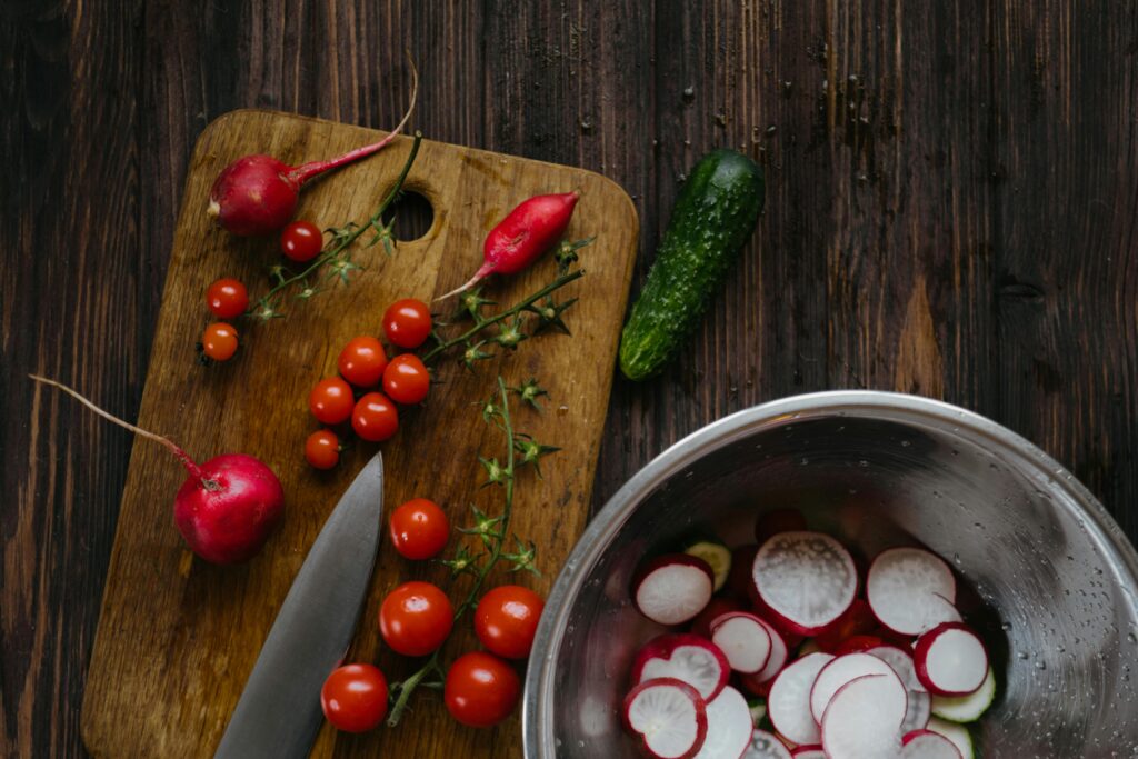 A vibrant arrangement of fresh vegetables on a wooden chopping board, ideal for healthy cooking concepts.